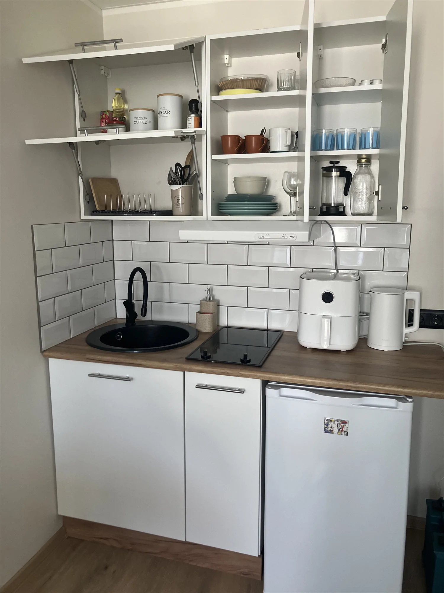 Kitchenette cabinetry, sink and open shelves at Malmi Studio.