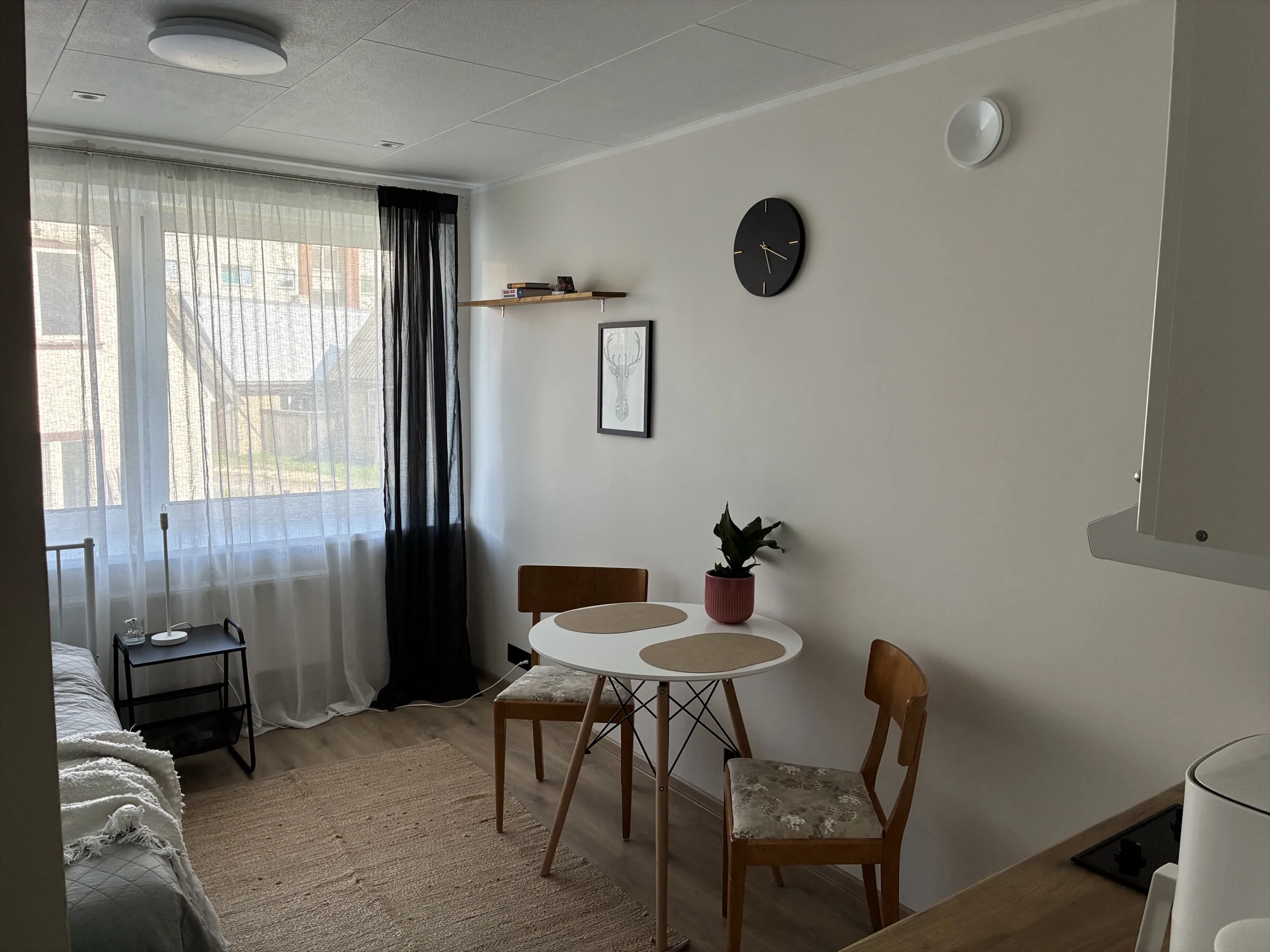 Living and dining area of Malmi Studio with a window and a table.