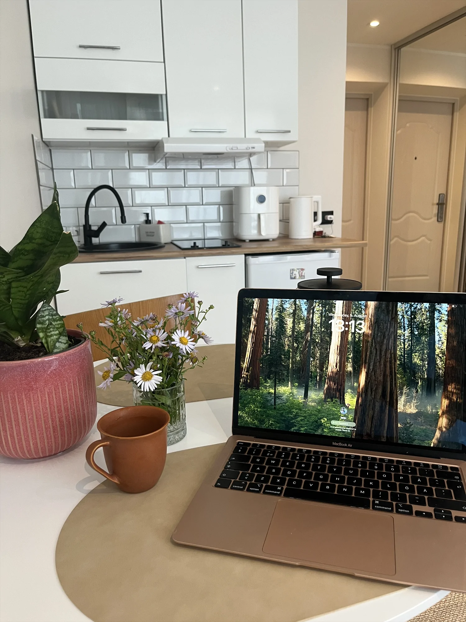 Laptop on a table beside the kitchenette at Malmi Studio.